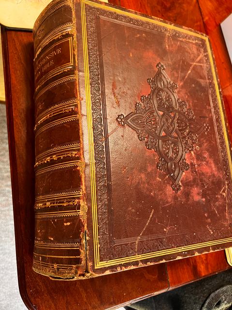 The front cover of The Comprehensive Family Bible, dark leather with an embossed central ornament and gilt borders